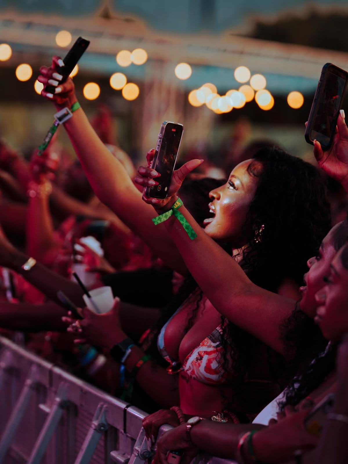 Fans at the barrier filming the stage at a concert